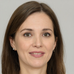 Joyful white adult female with long  brown hair and grey eyes