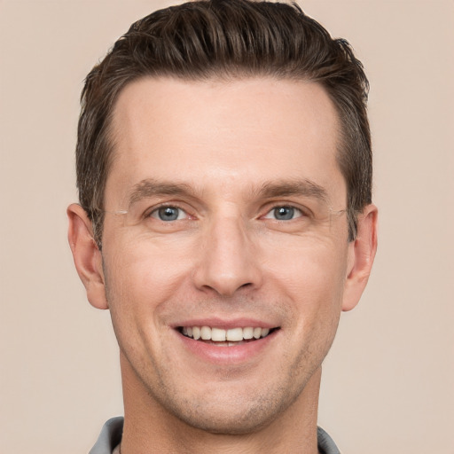 Joyful white adult male with short  brown hair and grey eyes