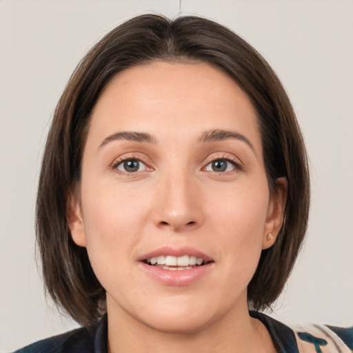 Joyful white young-adult female with medium  brown hair and grey eyes