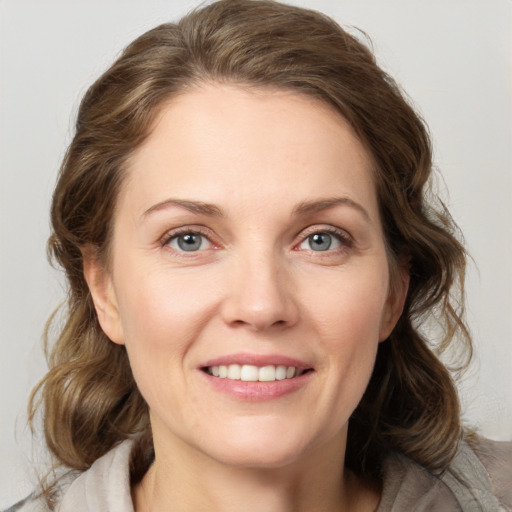 Joyful white young-adult female with medium  brown hair and green eyes