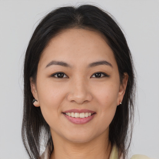 Joyful asian young-adult female with long  brown hair and brown eyes