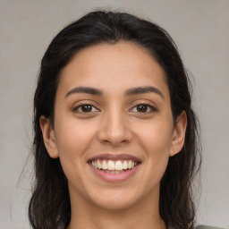 Joyful latino young-adult female with long  brown hair and brown eyes