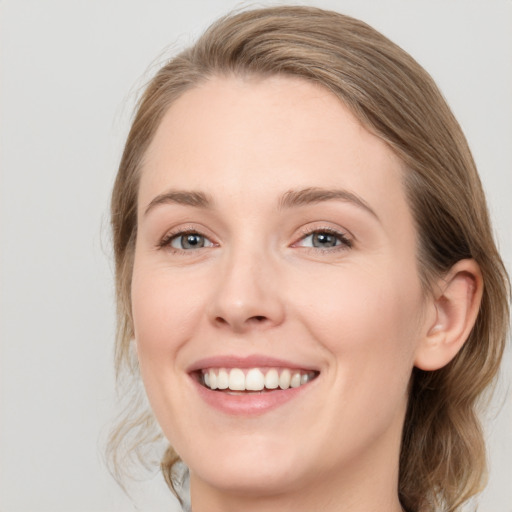 Joyful white young-adult female with medium  brown hair and grey eyes