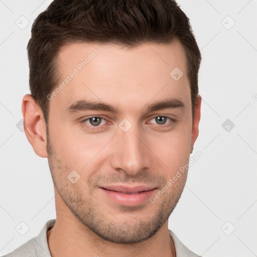 Joyful white young-adult male with short  brown hair and grey eyes