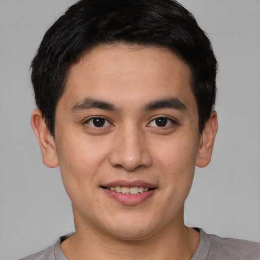 Joyful asian young-adult male with short  brown hair and brown eyes