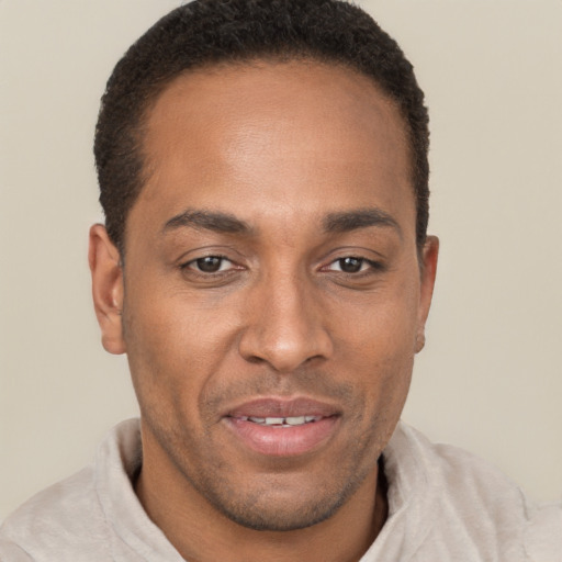 Joyful black adult male with short  brown hair and brown eyes