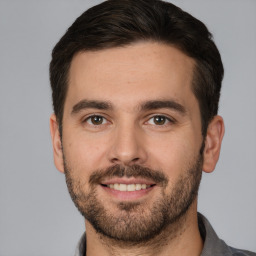 Joyful white young-adult male with short  brown hair and brown eyes