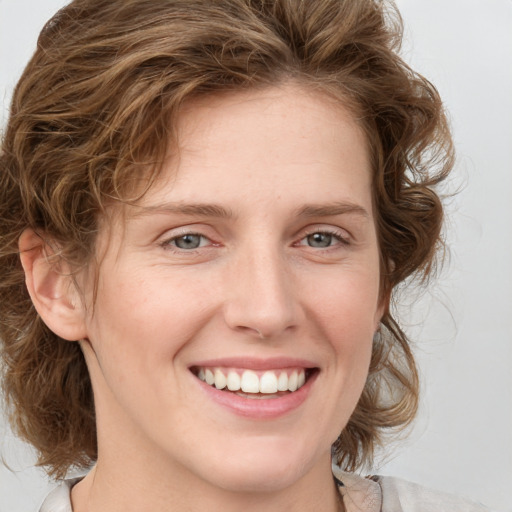 Joyful white young-adult female with medium  brown hair and green eyes