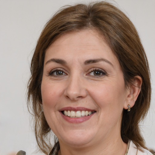 Joyful white adult female with medium  brown hair and grey eyes