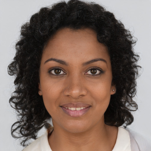 Joyful black young-adult female with medium  brown hair and brown eyes