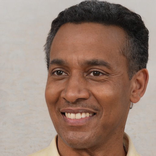 Joyful black adult male with short  black hair and brown eyes
