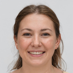 Joyful white young-adult female with medium  brown hair and grey eyes