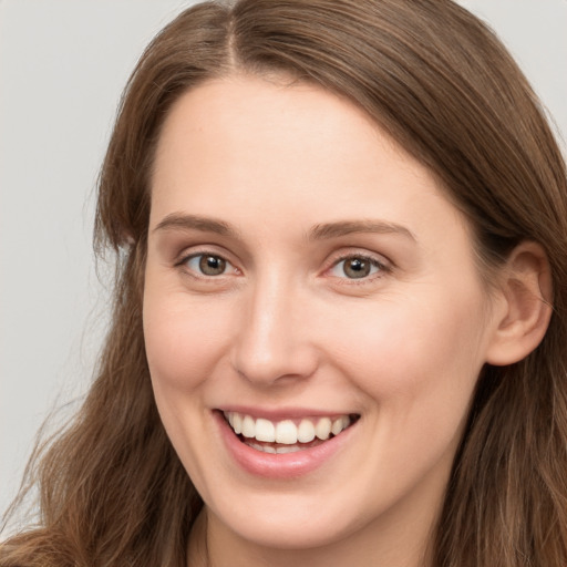 Joyful white young-adult female with long  brown hair and grey eyes