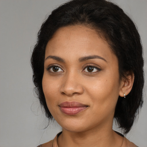 Joyful black young-adult female with medium  brown hair and brown eyes