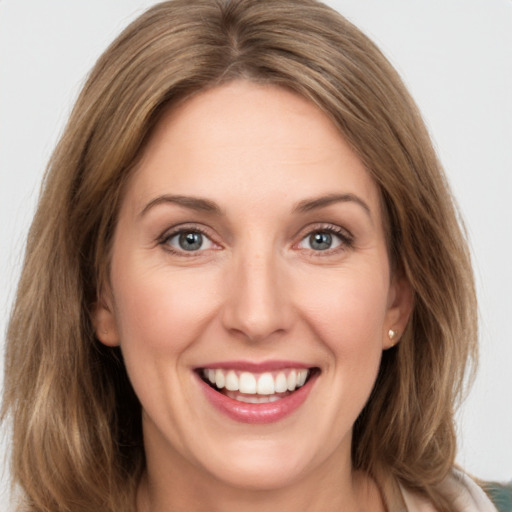 Joyful white young-adult female with medium  brown hair and green eyes