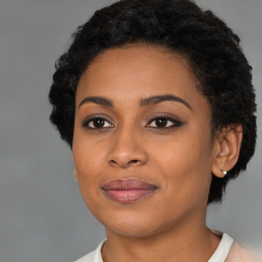 Joyful black young-adult female with short  brown hair and brown eyes