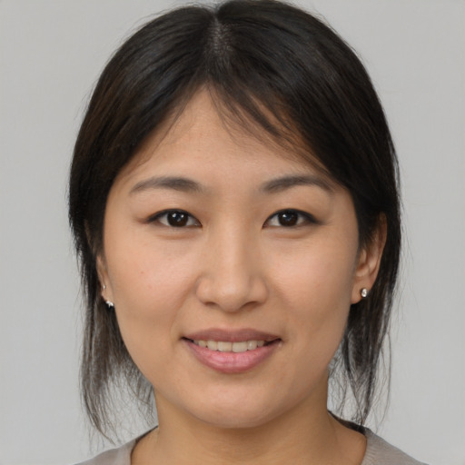 Joyful asian young-adult female with medium  brown hair and brown eyes