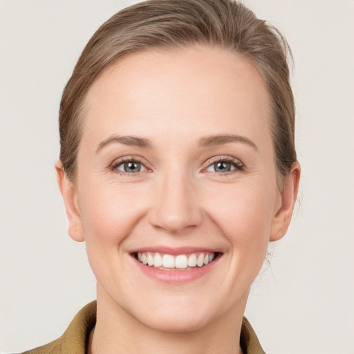 Joyful white young-adult female with medium  brown hair and grey eyes