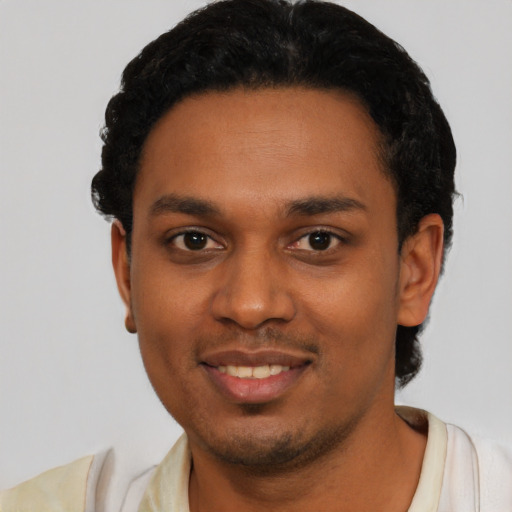 Joyful black young-adult male with short  black hair and brown eyes