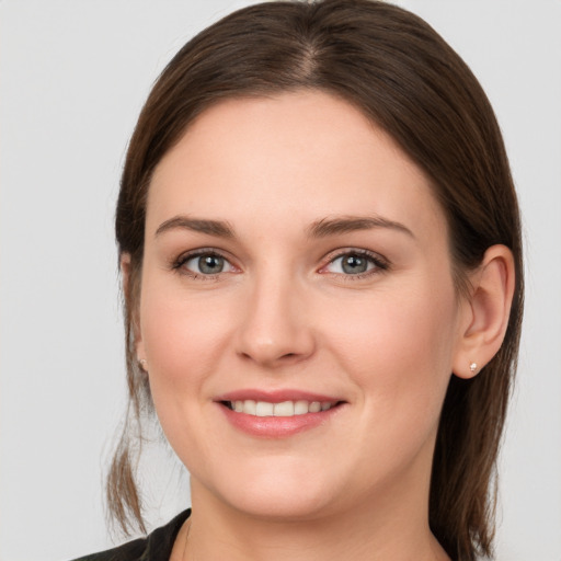 Joyful white young-adult female with medium  brown hair and grey eyes