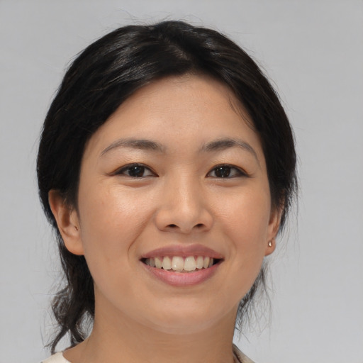 Joyful asian young-adult female with medium  black hair and brown eyes