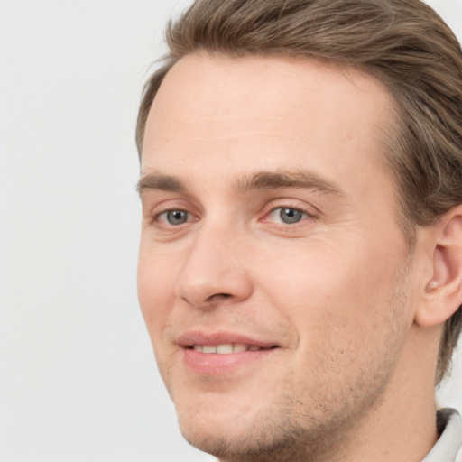 Joyful white young-adult male with short  brown hair and grey eyes