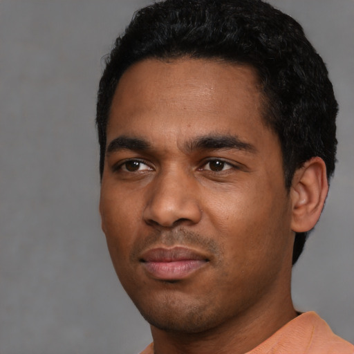 Joyful black young-adult male with short  black hair and brown eyes
