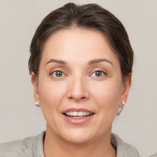 Joyful white young-adult female with short  brown hair and grey eyes