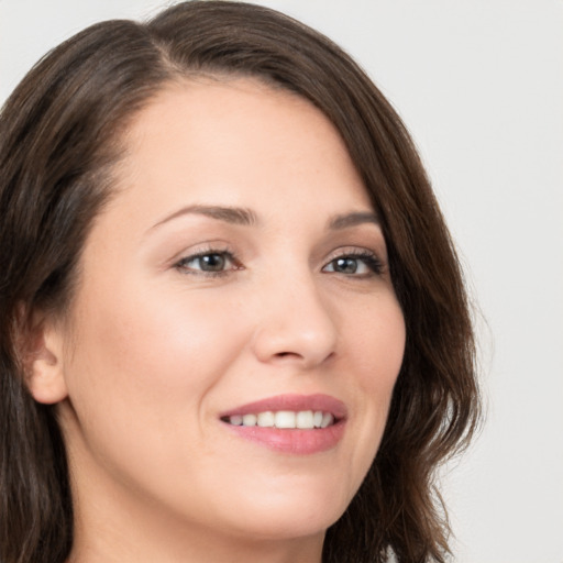 Joyful white young-adult female with long  brown hair and brown eyes