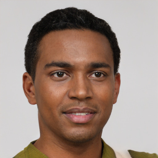 Joyful black young-adult male with short  black hair and brown eyes