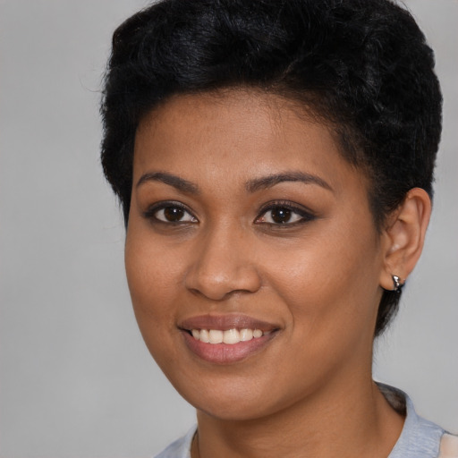 Joyful black young-adult female with short  brown hair and brown eyes