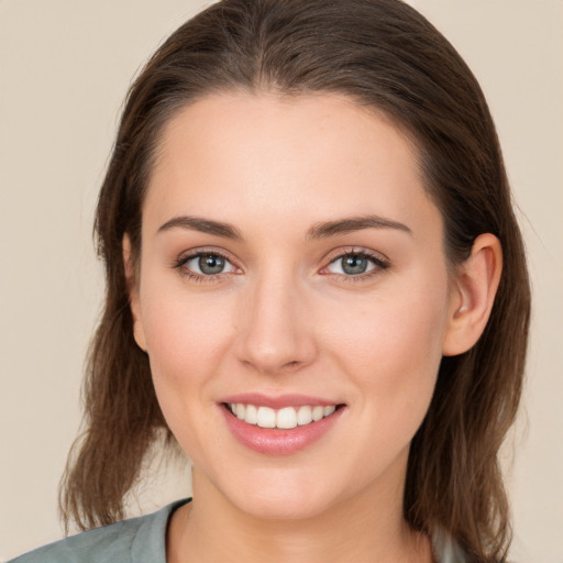 Joyful white young-adult female with medium  brown hair and grey eyes