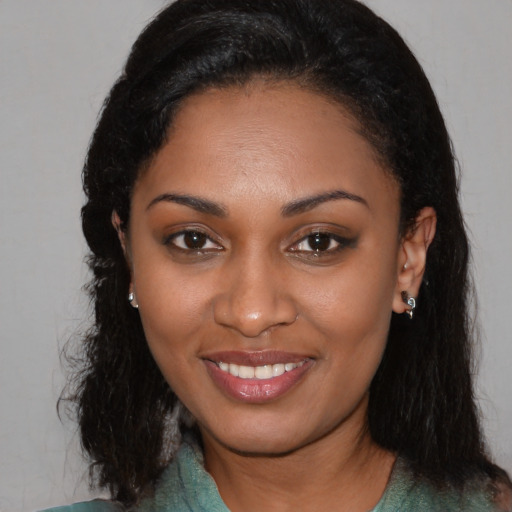 Joyful black young-adult female with long  brown hair and brown eyes