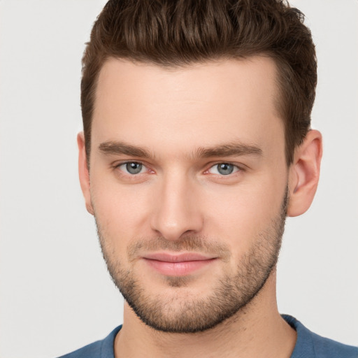 Joyful white young-adult male with short  brown hair and grey eyes