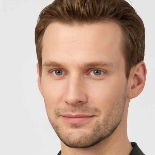 Joyful white young-adult male with short  brown hair and grey eyes