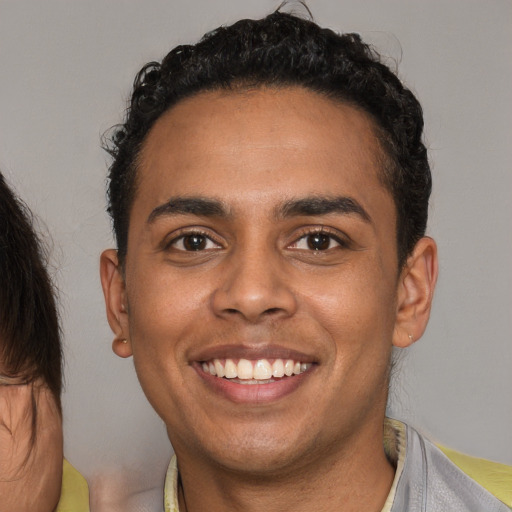 Joyful black young-adult male with short  brown hair and brown eyes