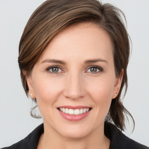 Joyful white young-adult female with medium  brown hair and grey eyes