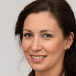 Joyful white adult female with long  brown hair and brown eyes