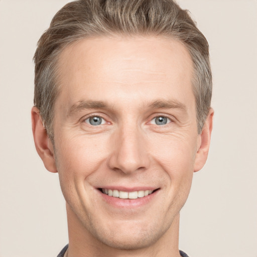 Joyful white adult male with short  brown hair and grey eyes