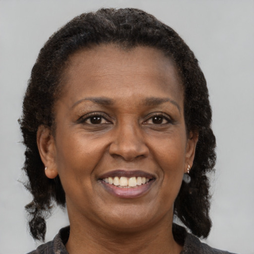Joyful black adult female with short  brown hair and brown eyes
