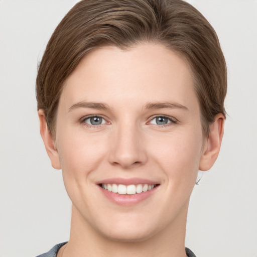 Joyful white young-adult female with short  brown hair and grey eyes