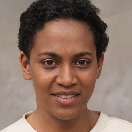 Joyful black young-adult female with short  brown hair and brown eyes
