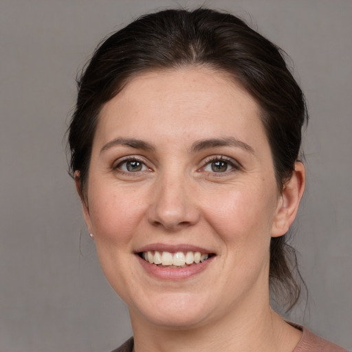 Joyful white young-adult female with medium  brown hair and grey eyes