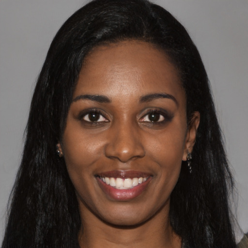 Joyful black young-adult female with long  black hair and brown eyes