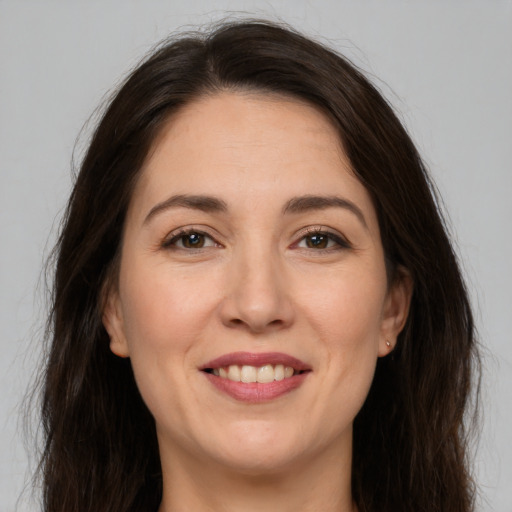 Joyful white young-adult female with long  brown hair and brown eyes