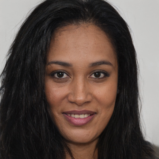 Joyful black young-adult female with long  brown hair and brown eyes