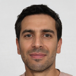 Joyful white young-adult male with short  black hair and brown eyes