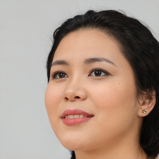 Joyful asian young-adult female with long  black hair and brown eyes