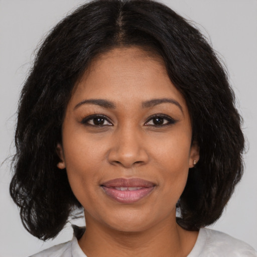 Joyful black young-adult female with medium  brown hair and brown eyes