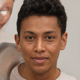 Joyful latino young-adult male with short  brown hair and brown eyes